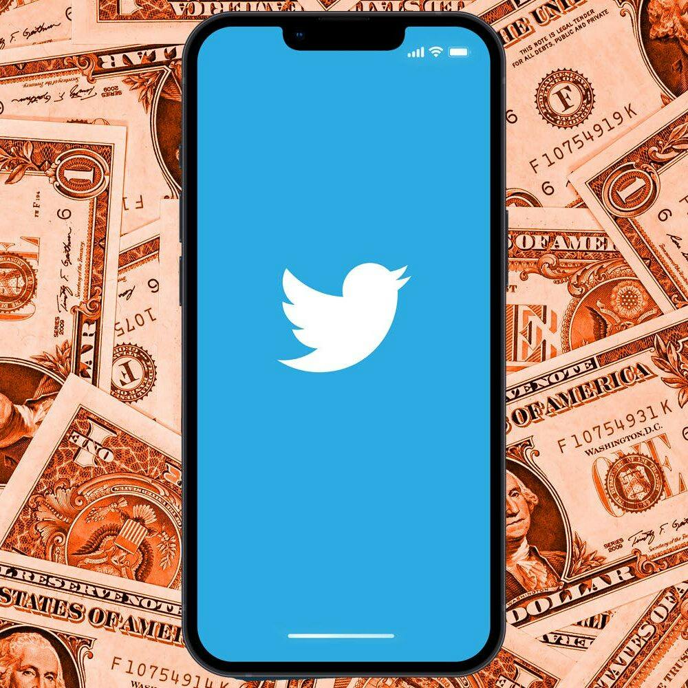 phone with twitter logo over background of dollar bills