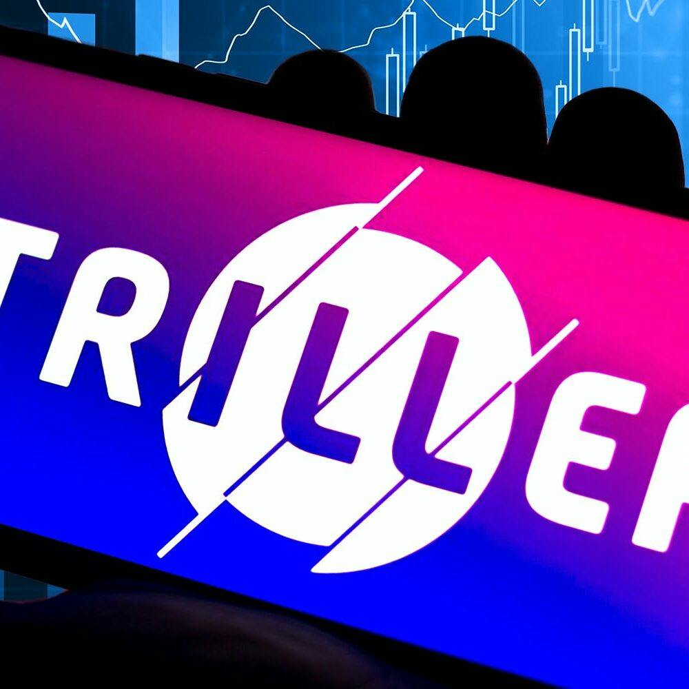 Triller logo on a smartphone over stock market background