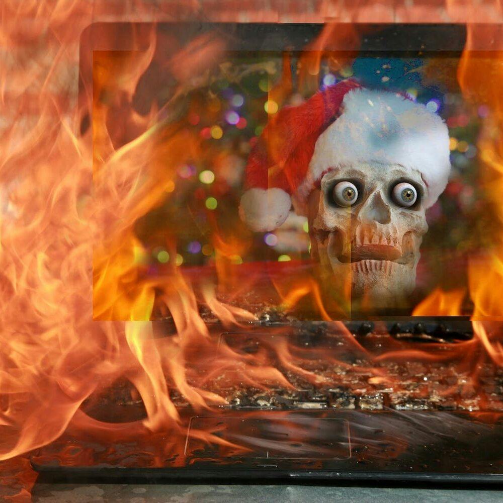 christmas eulogy featured image - a skull in a santa hat on fire on a laptop