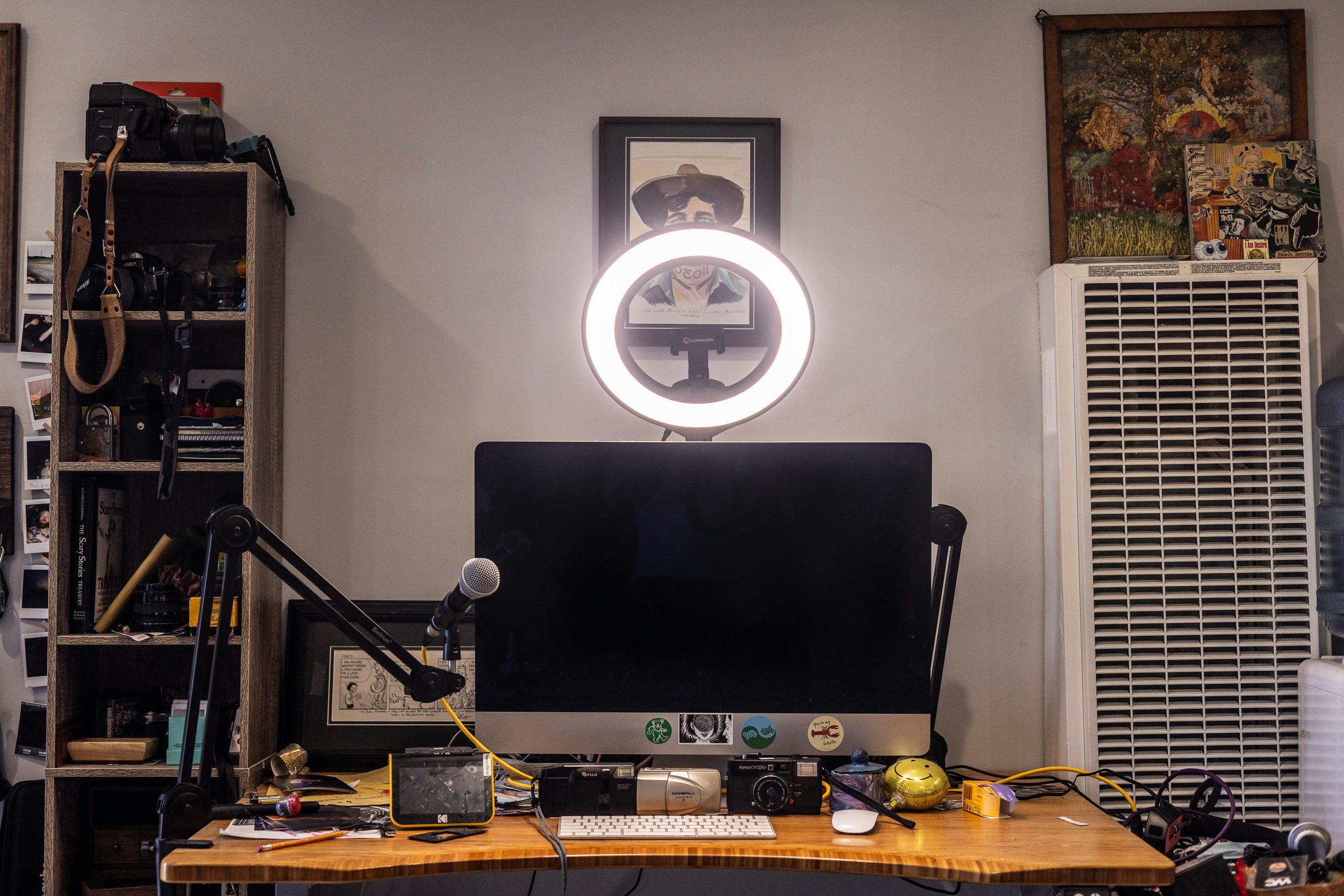 a lume cube ring light mini mounted above a desk with a iMac on it.