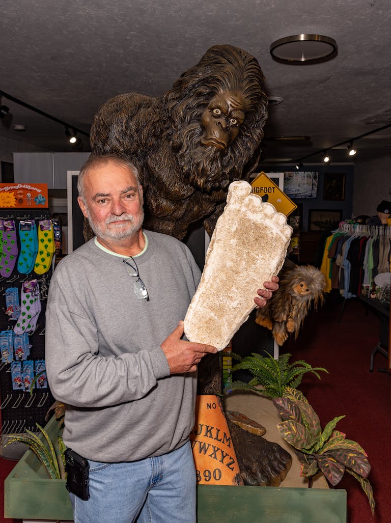 Elinchrom Three review - Stephen Barcelo of the Cryptozoological and Paranormal Museum holding a big foot foot cast in front of a sashquash statue