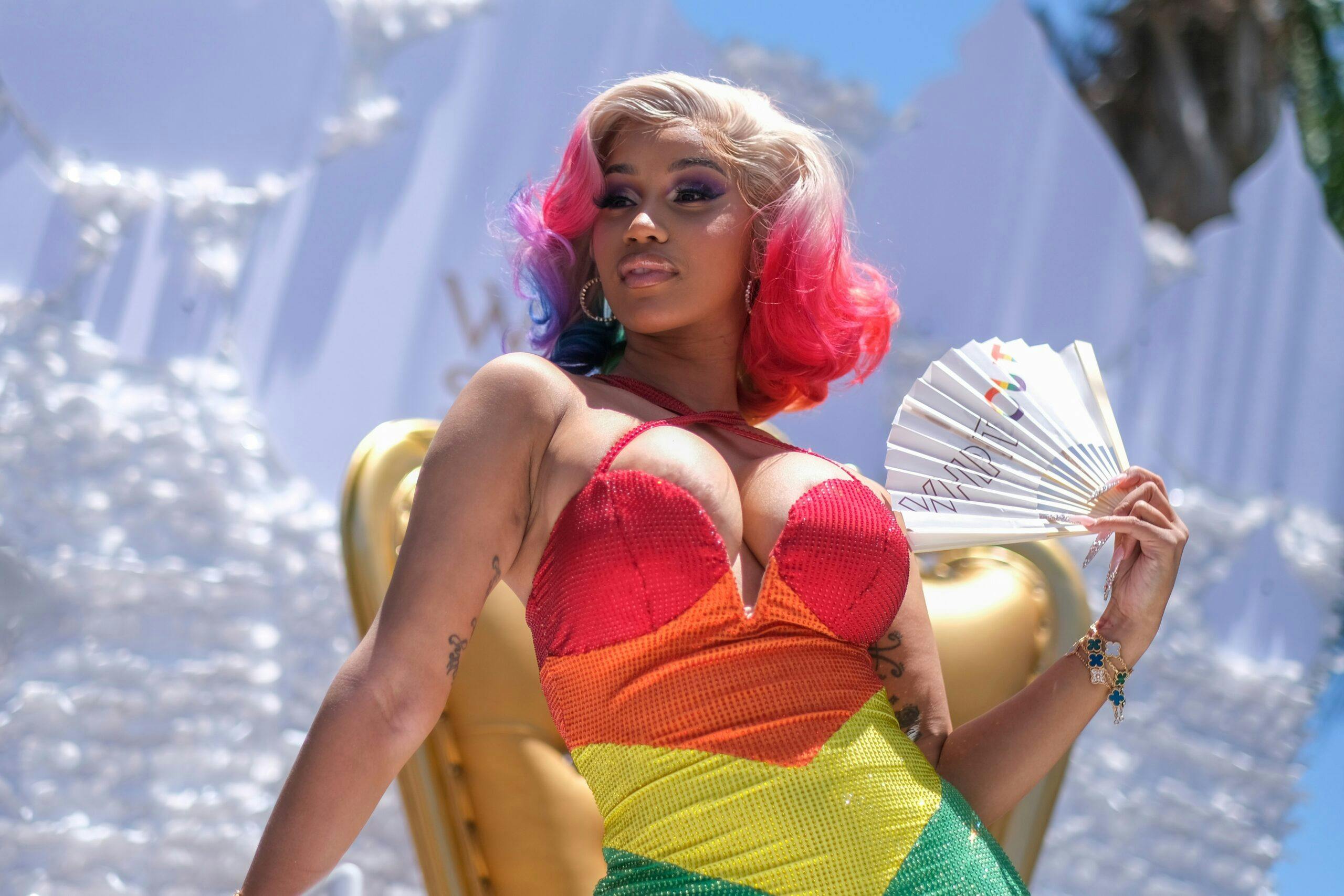 Cardi B attends the WEHO Pride Parade in West Hollywood on Sunday June 5, 2022, dressed in a rainbow dress and holding a fan.
