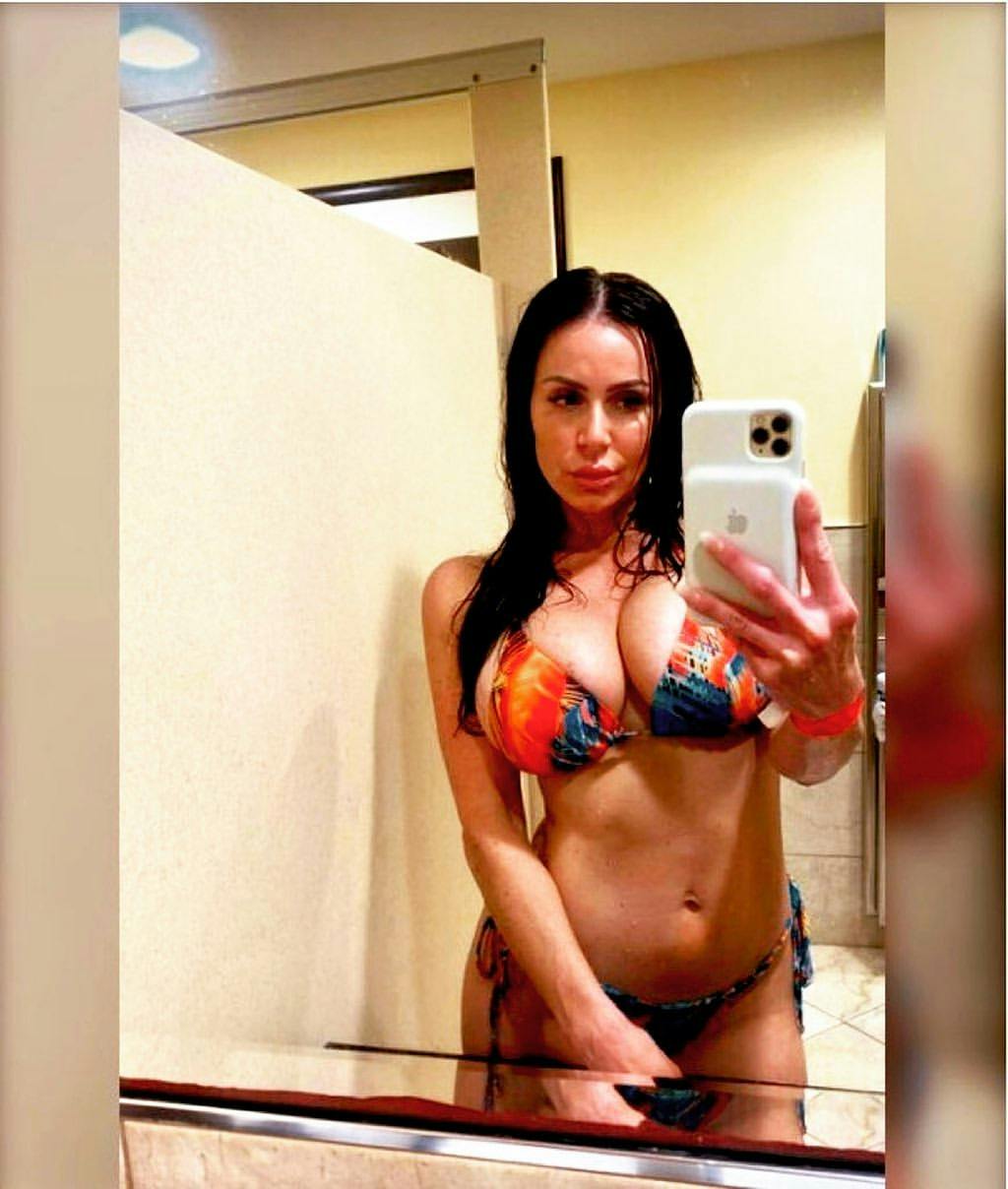 Adult star Kendra Lust wearing a patterned bikini taking a mirror selfie.