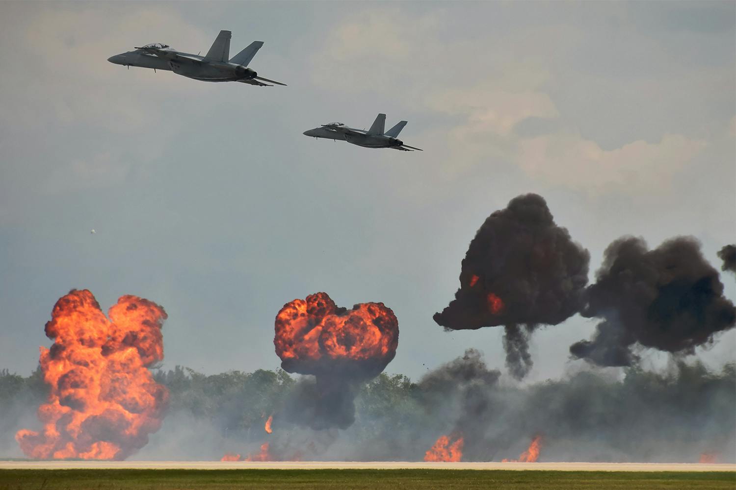 jets fly over ground explosions